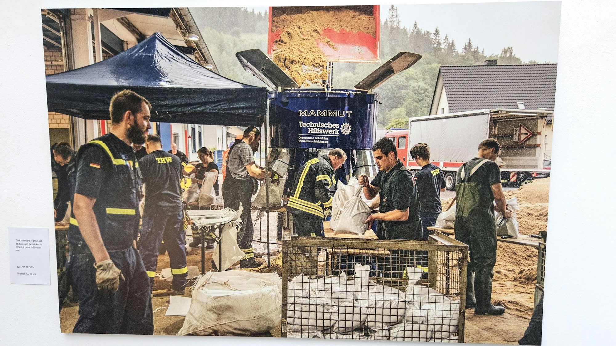 THW-Helfer füllen an Tischen Sandsäcke.