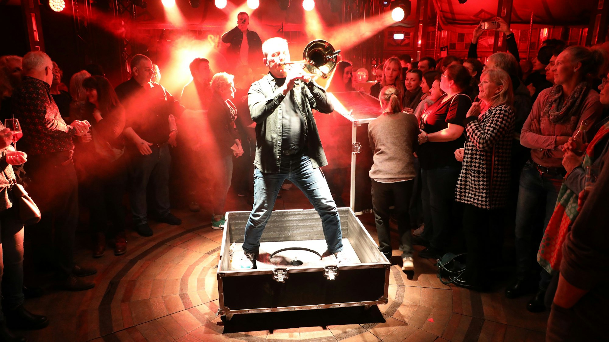 Posaunist Clemens Tewinkel steht in einem offenen Koffer.