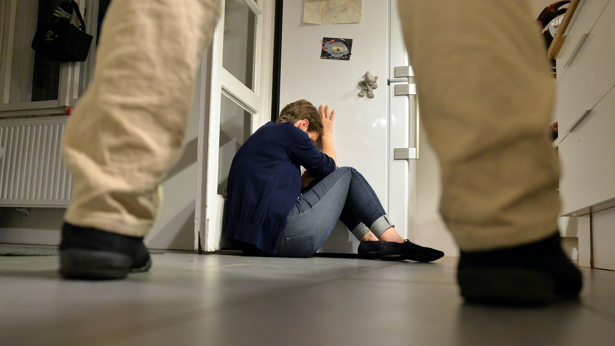 Gestelltes Bild zum Thema häusliche Gewalt - Eine Frau versucht, sich vor der Gewalt eines Mannes zu schützen.