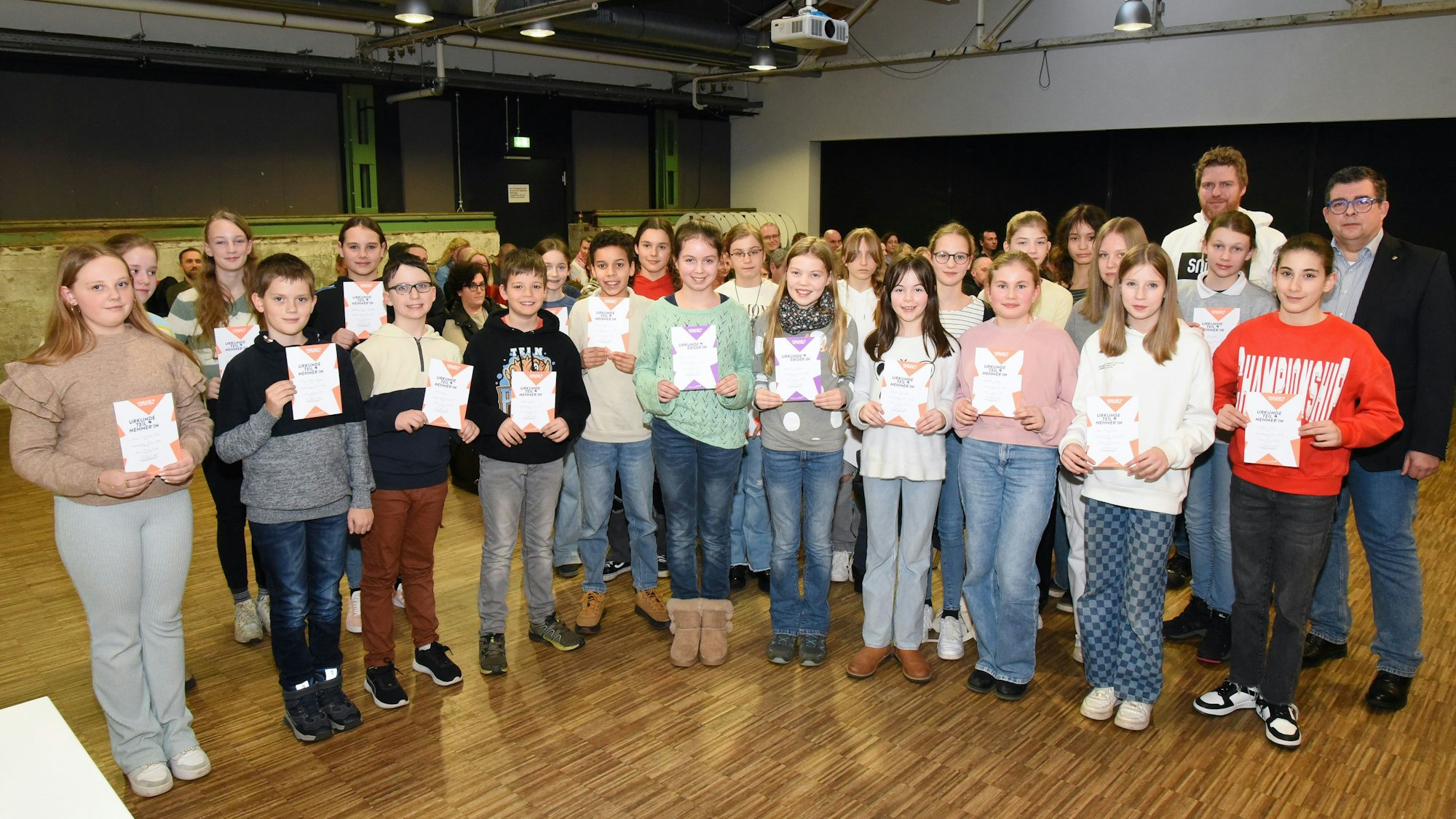 Eine Gruppe Kinder steht mit Urkunden in Händen nebeneinander.