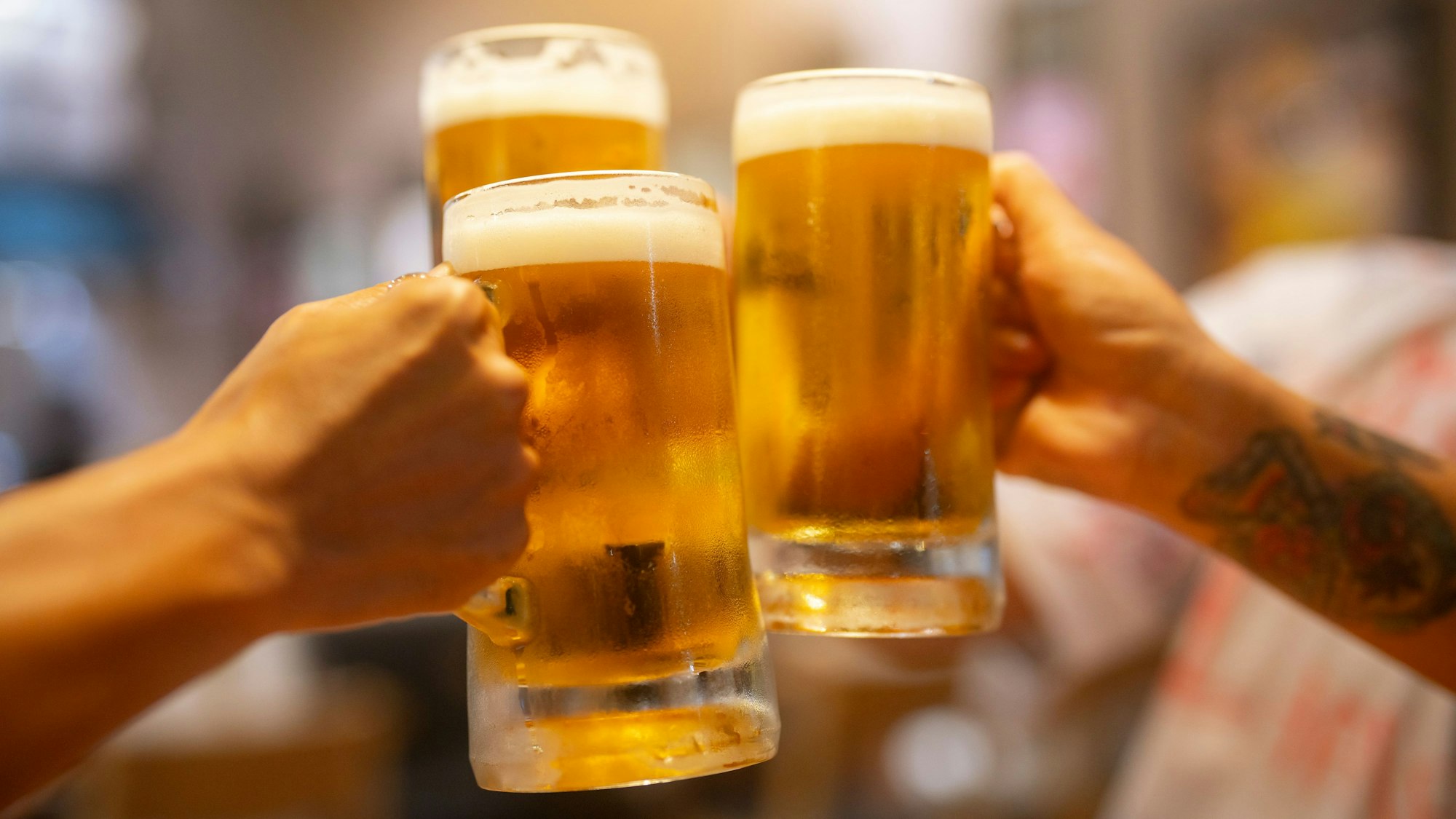 Freunde stoßen mit großen Biergläsern an