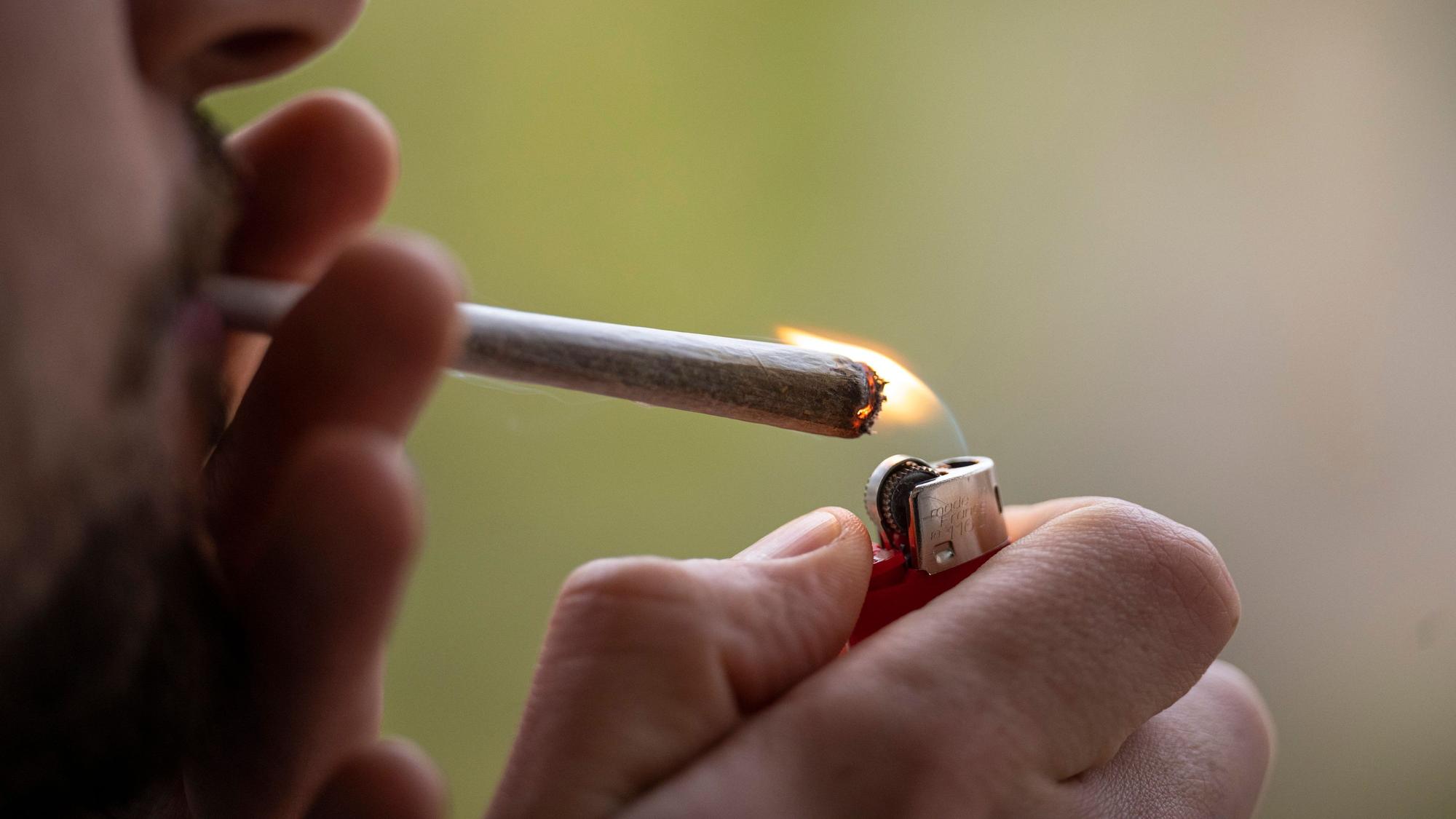 Ein Mann zündet sich einen Joint an.