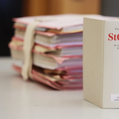 Gerichtsakten und Bücher zu Strafgesetzbuch und Strafprozessordnung liegen bzw. stehen liegen auf einem Tisch in einem Gericht.