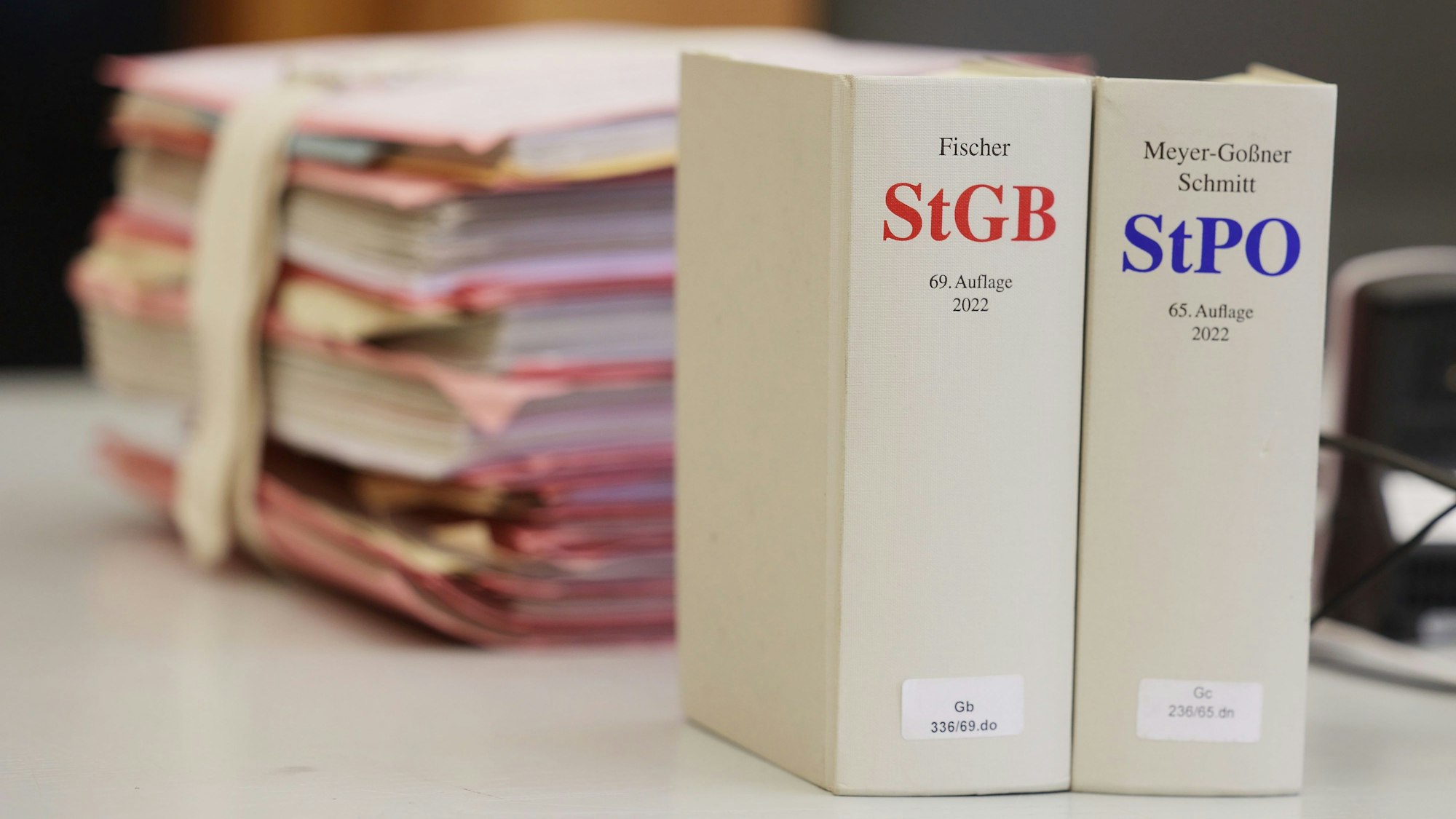 Gerichtsakten und Bücher zu Strafgesetzbuch und Strafprozessordnung liegen bzw. stehen liegen auf einem Tisch im Landgericht.