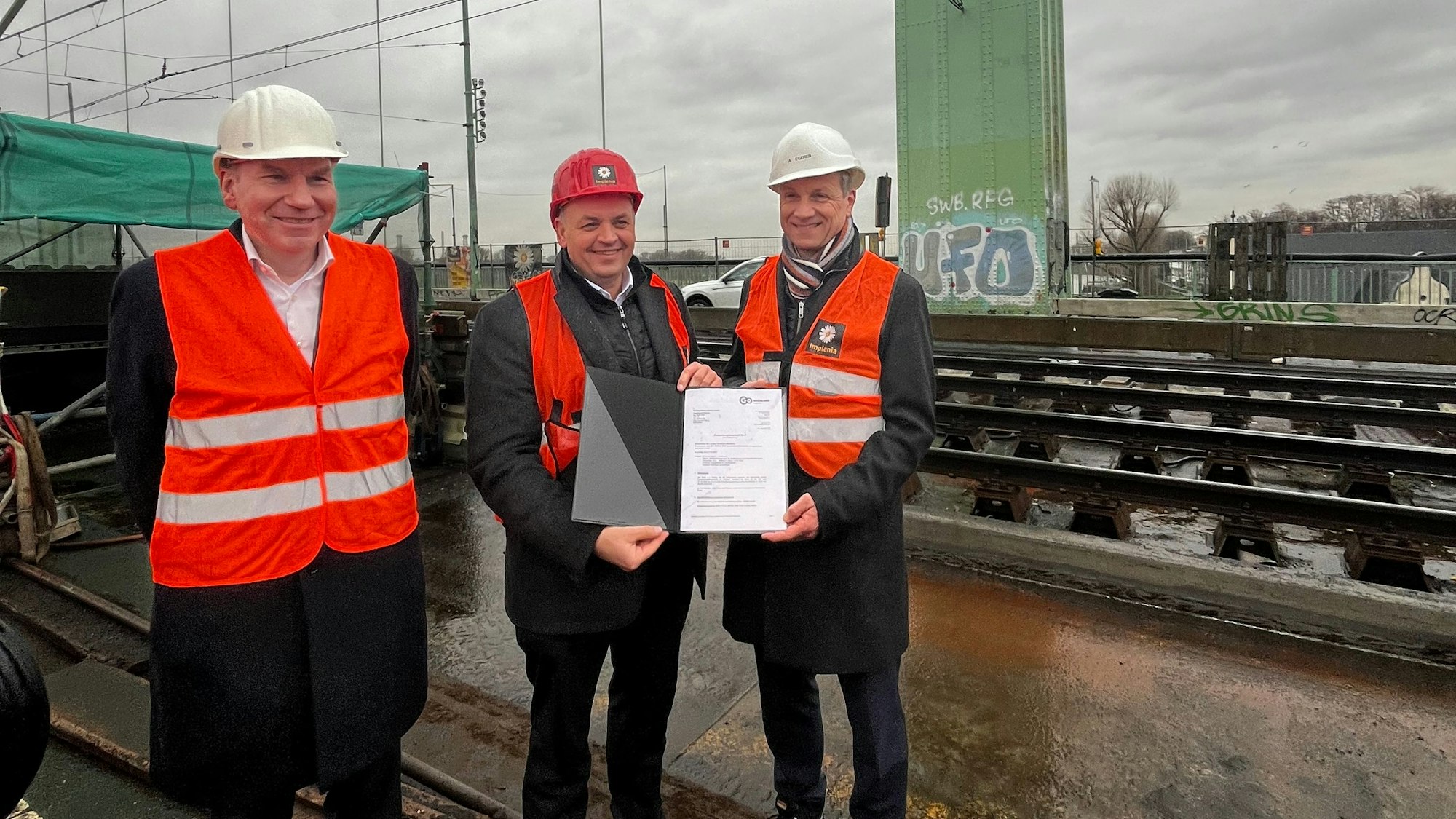 NRW-Staatssekretär Viktor Haase (mitte) übergab den Förderbescheid vor Ort an Kölns Verkehrsdezernenten Ascan Egerer (r.) und KVB-Vorstand Jörn Schwarze (l.).