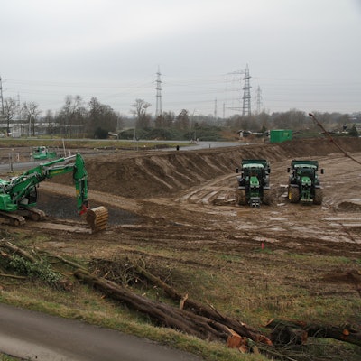 Großbaustelle mit zwei Baugruben sowie grünen Baggern und Traktoren.
