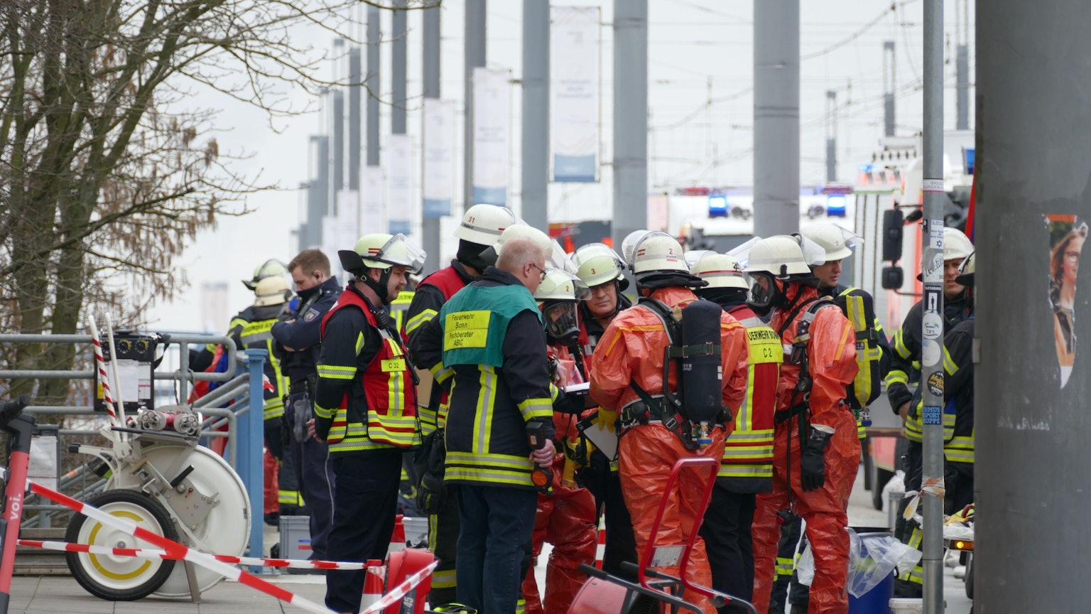 Feuerwehrleute in Schutzanzügen erkunden die Lage am Brückenforum in Bonn.