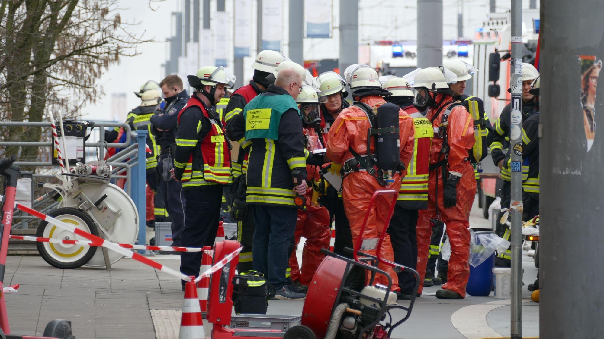 Feuerwehrleute in Schutzanzügen erkunden die Lage am Brückenforum in Bonn.