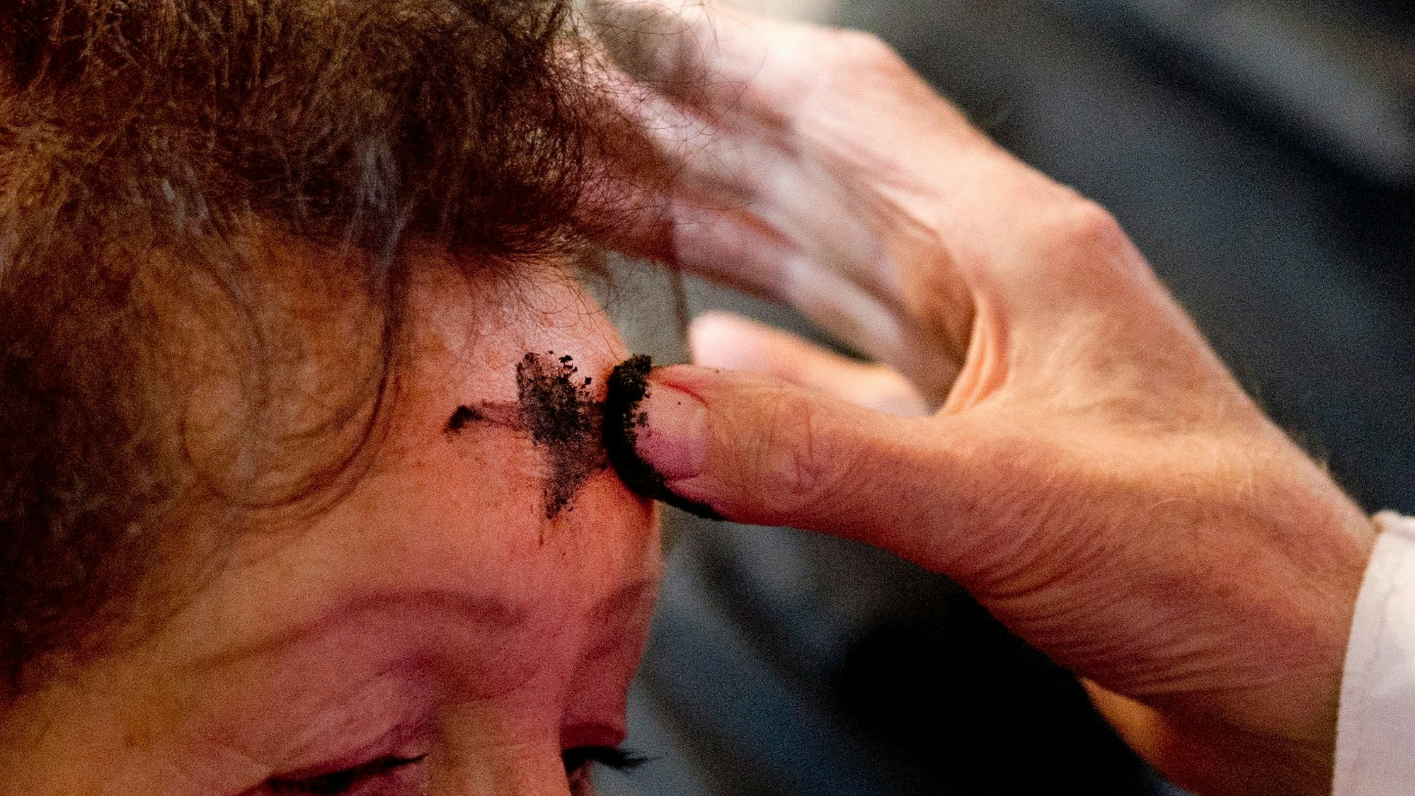 Der ehemalige Dompropst Günter Berghaus macht am Mittwoch im Dom in Essen ein Aschekreuz auf die Stirn einer Frau. Mit dem Aschermittwoch beginnt für die Christen die Fastenzeit.