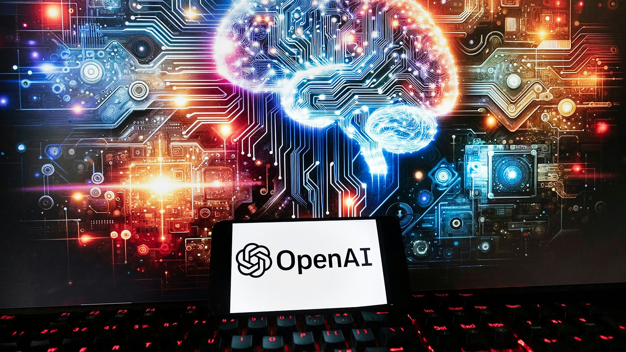 FILE - The OpenAI logo is displayed on a cell phone with an image on a computer monitor generated by ChatGPT's Dall-E text-to-image model, Friday, Dec. 8, 2023, in Boston. The maker of ChatGPT is now diving into the world of AI-generated video. Meet Sora — OpenAI’s new text-to-video generator. The tool, which the San Francisco-based company unveiled on Thursday, Feb. 16, 2024 uses generative artificial intelligence to instantly create short videos based on written commands. (AP Photo/Michael Dwyer, File)