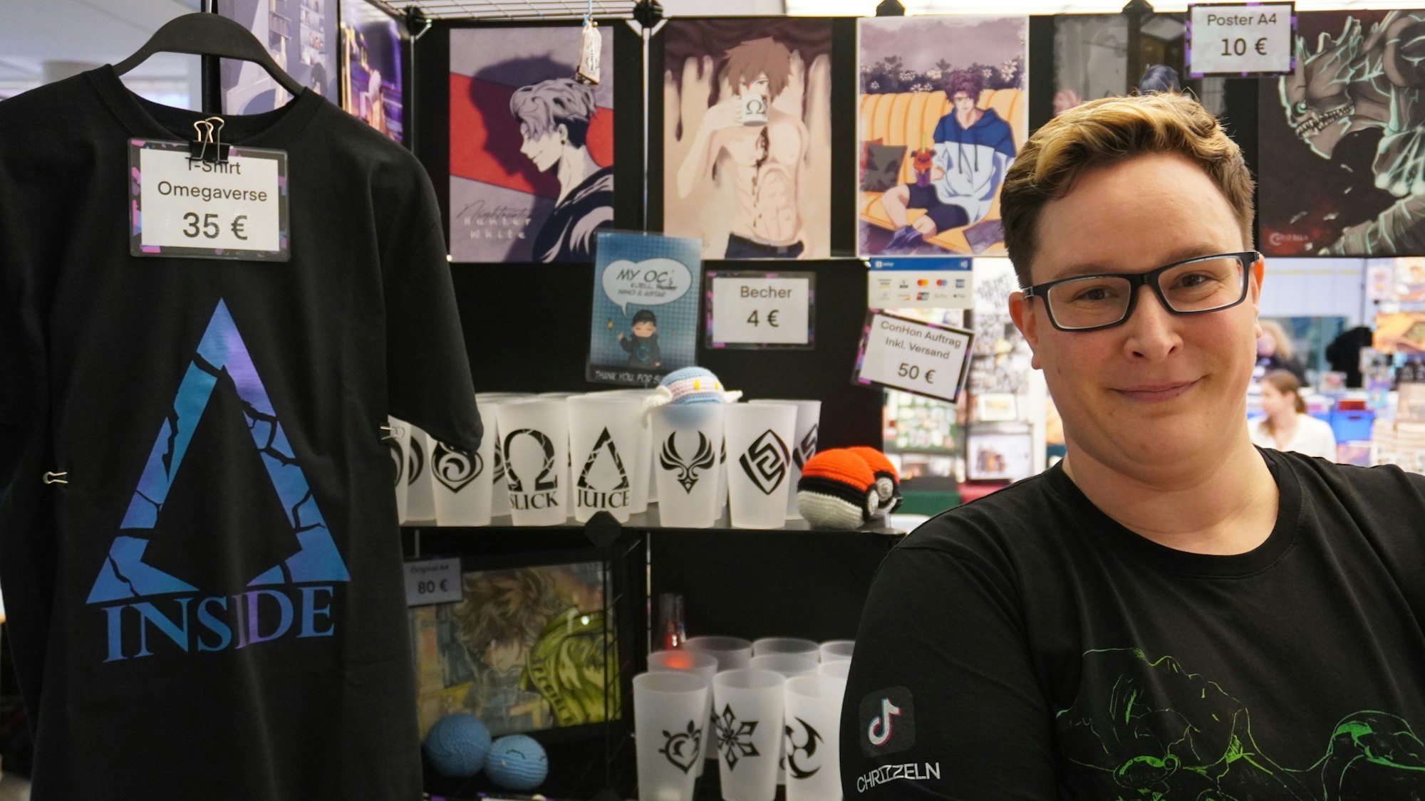 Auf dem Foto ist eine Teilnehmerin der Manga-Convention in Bergheim zu sehen. Sie bietet verschiedene Artikel mit Manga-Motiven an.