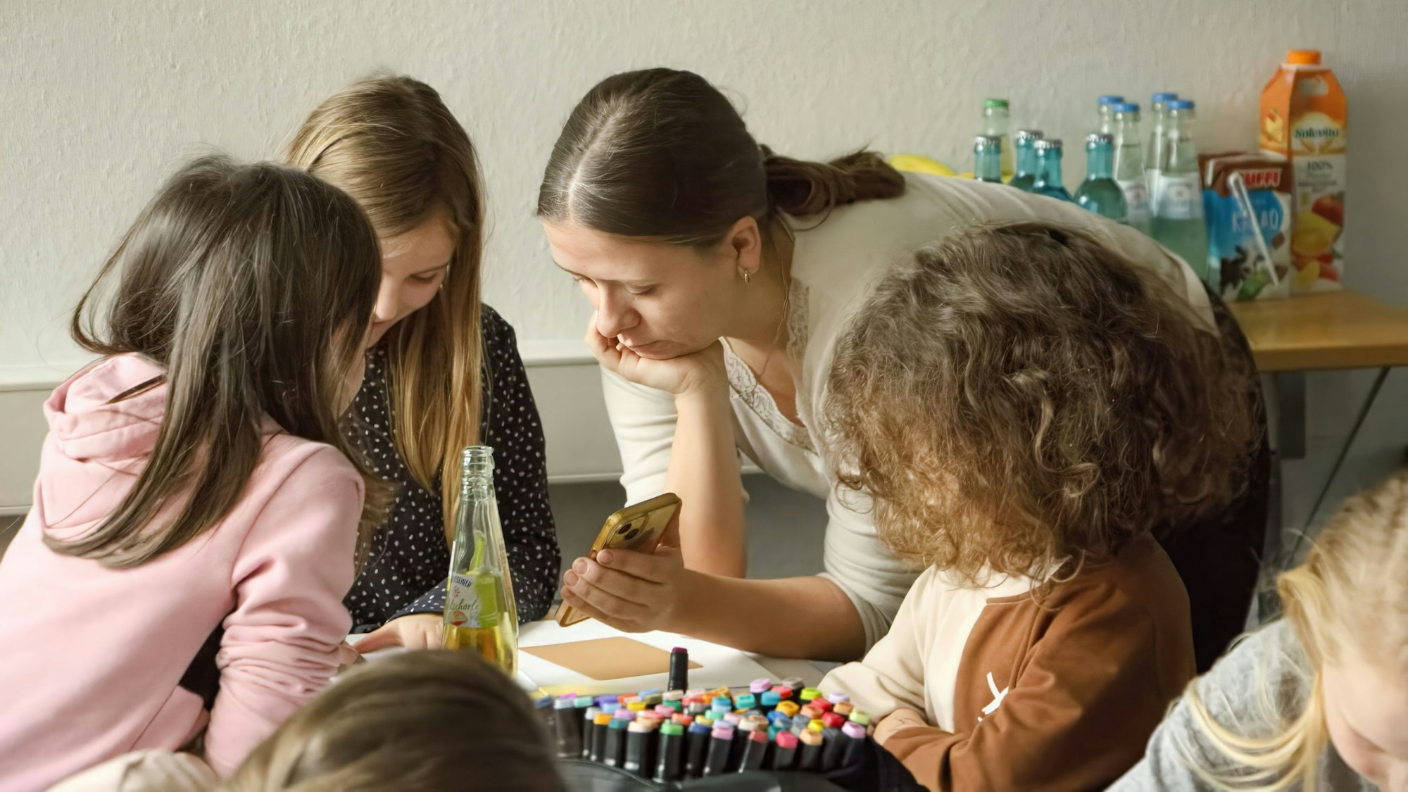 Im Fluthilfebüro des Caritasverbandes Euskirchen malen Kinder mit Saskia Reder.