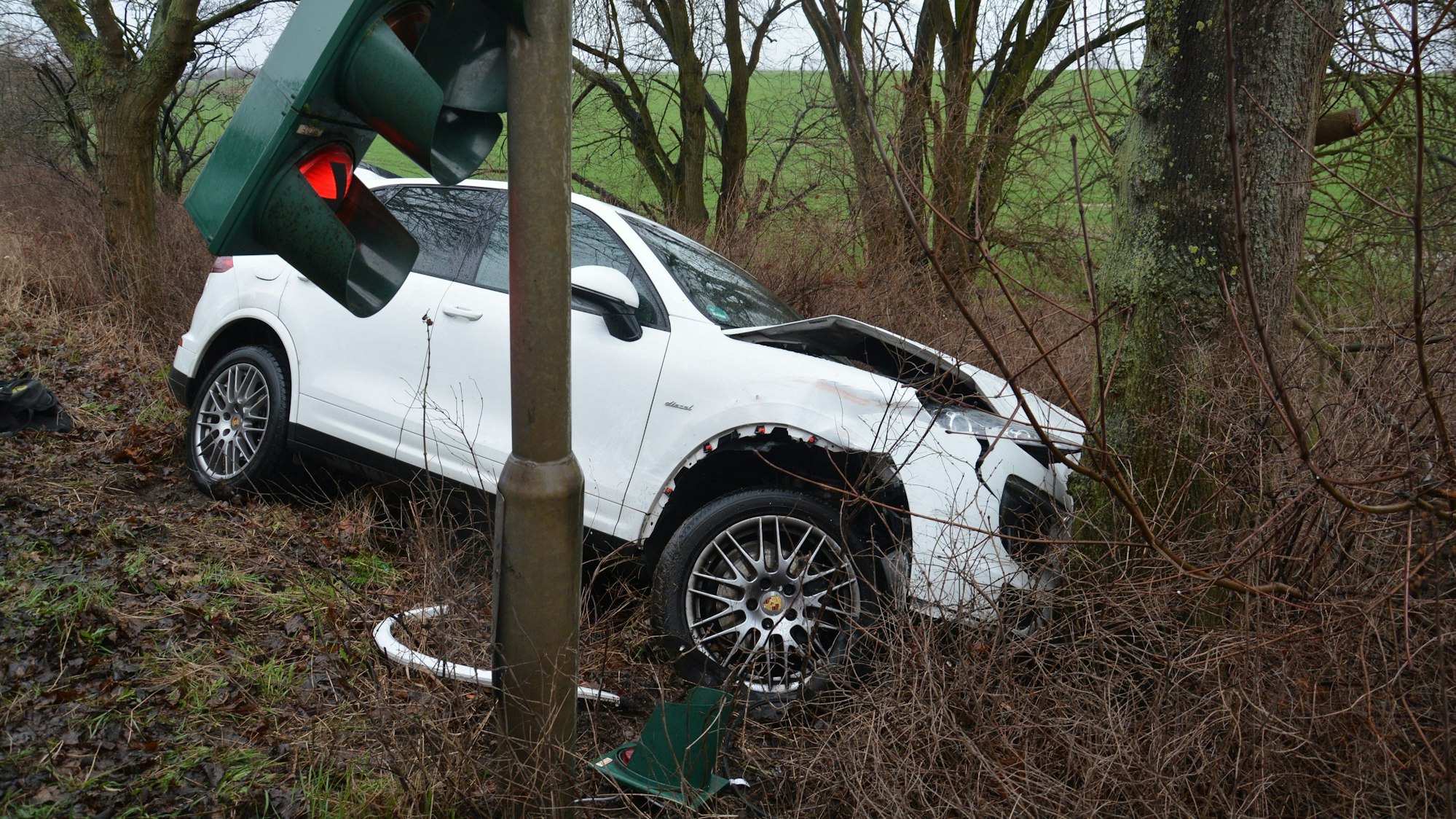 Ein Wagen liegt nach einem Unfall seitlich in einer Böschung.