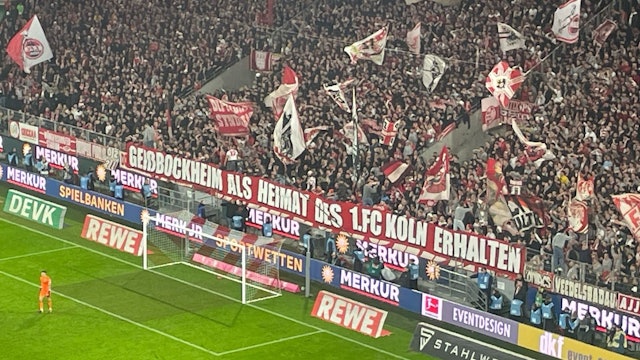 FC-Fans in der Südkurve des Rheinenergie-Stadions zeigen ein Banner mit der Aufschrift: „Geißbockheim als Heimat des 1. FC Köln erhalten“