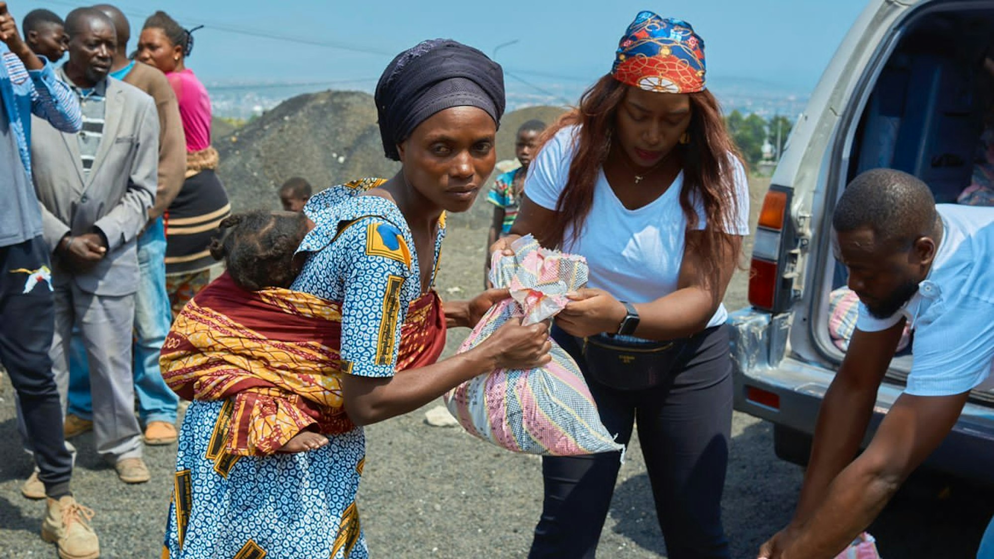 Die Kölnerin Deborath (Mitte) verteilt Hilfspakete an Geflüchtete.