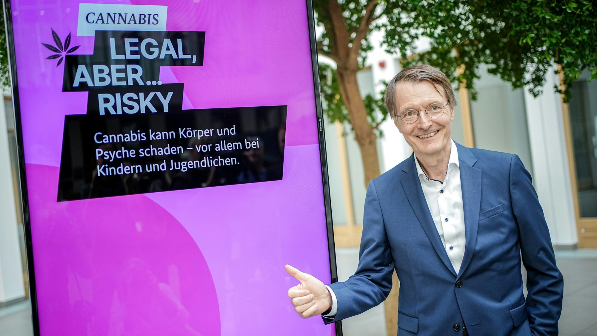 Karl Lauterbach (SPD), Bundesminister für Gesundheit, steht im Sommer 2023 vor dem Plakat einer Aufklärungskampagne zu den Gefahren von Cannabis.