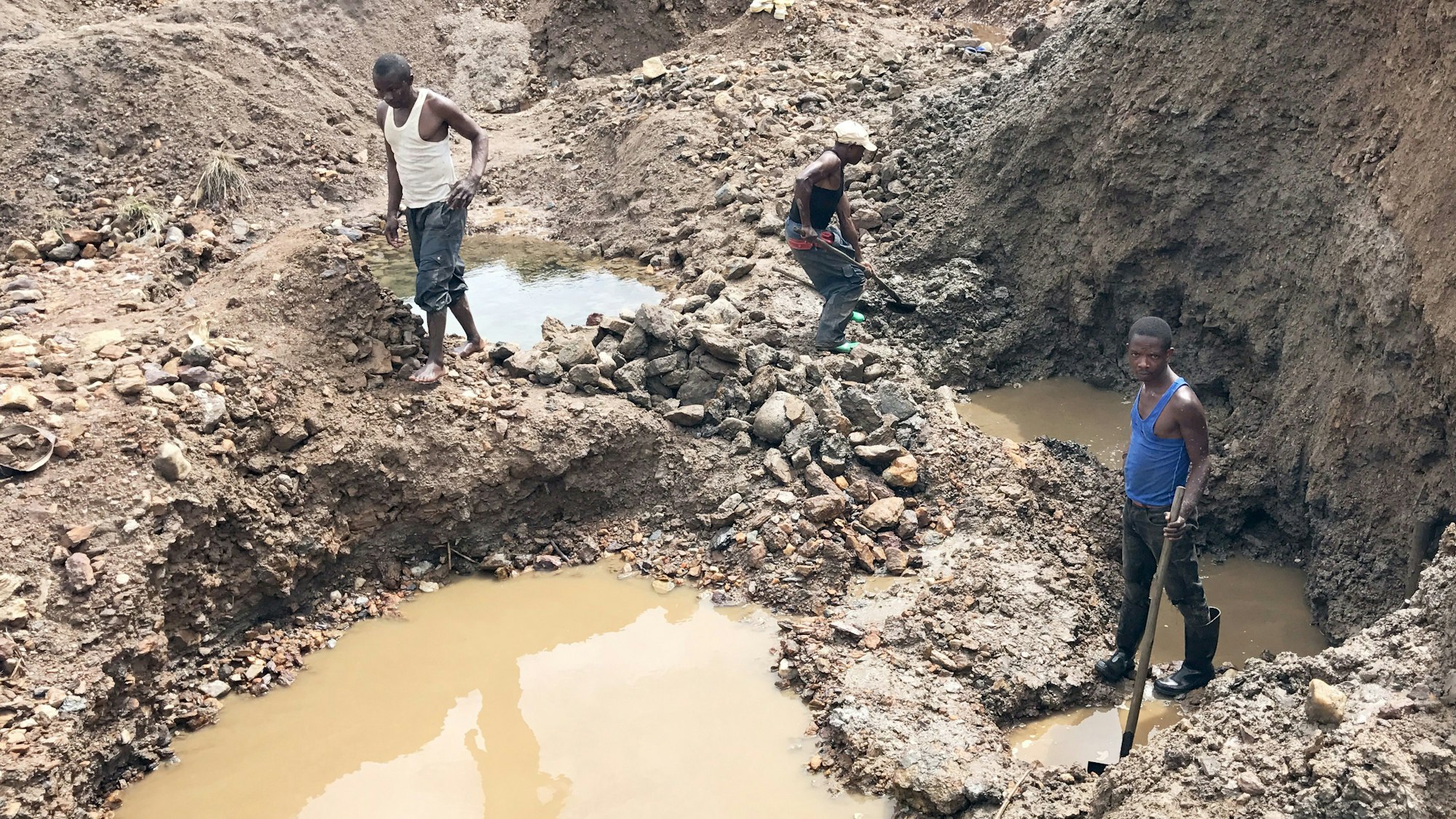 Drei Bergarbeiter stehen am 03.12.2016 in einer kleinen Mine in der ostkongolesischen Provinz Süd-Kivu.