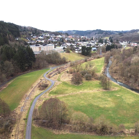 Blick auf das Tal von Richtung Olef in Richtung Schleiden mit der Olef und den grünen Wiesen.