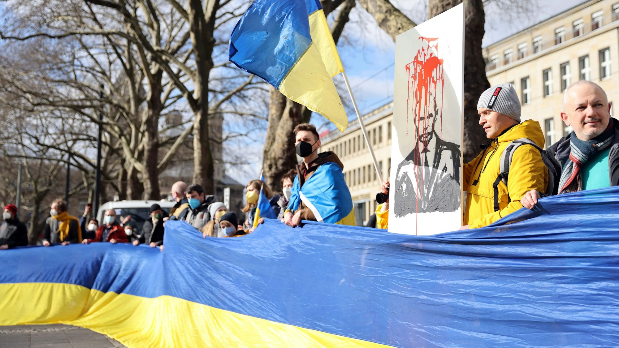 Menschen halten eine lange Ukraine Flagge