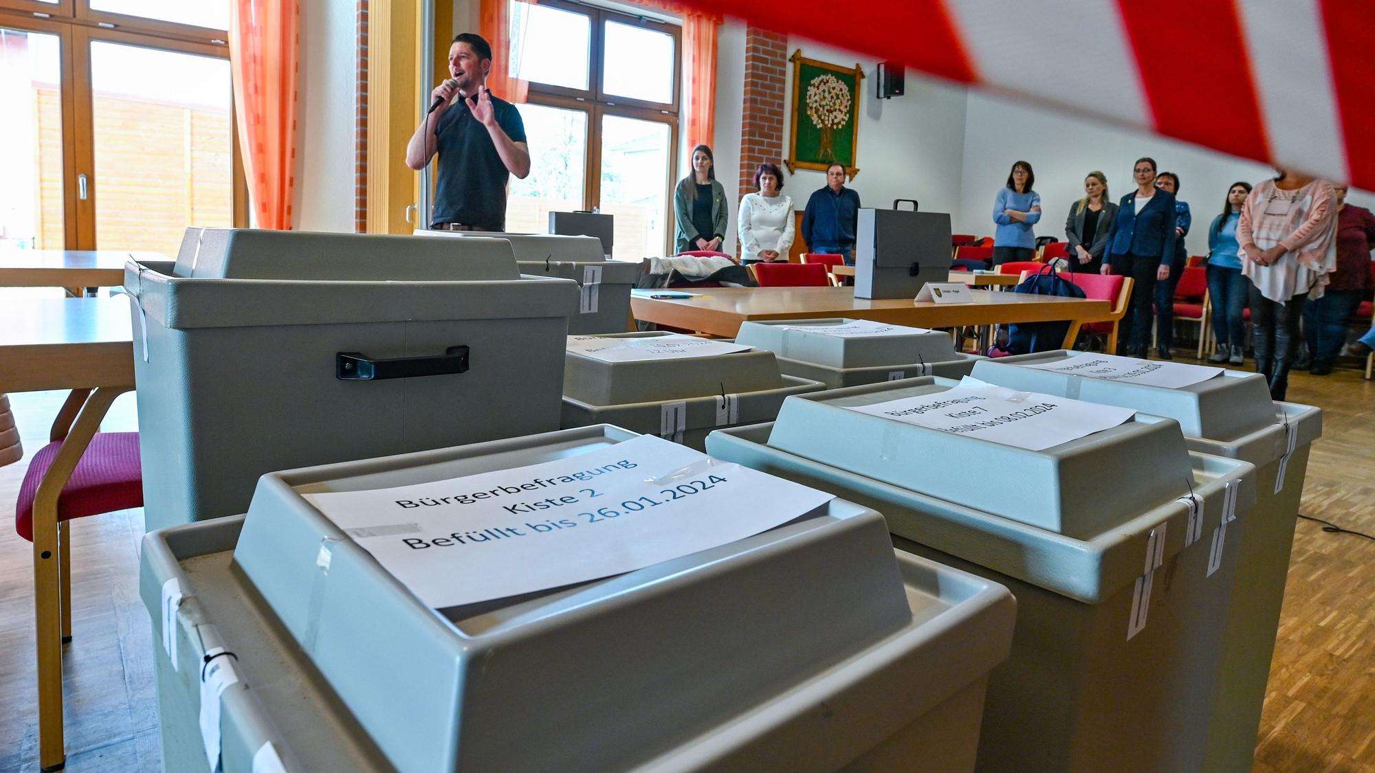 Mitarbeiter der Gemeinde Grünheide warten auf den Beginn der Auszählung der Briefwahl der Bürgerbefragung zur Tesla-Erweiterung.