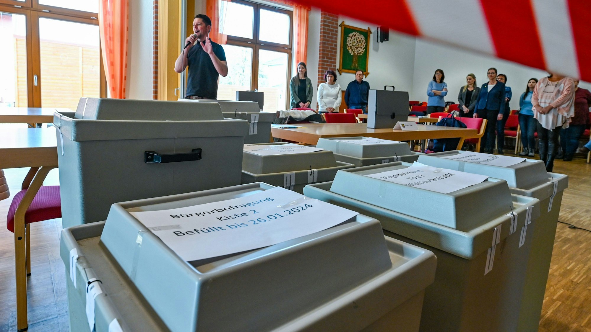 Mitarbeiter der Gemeinde Grünheide warten auf den Beginn der Auszählung der Briefwahl der Bürgerbefragung zur Tesla-Erweiterung.