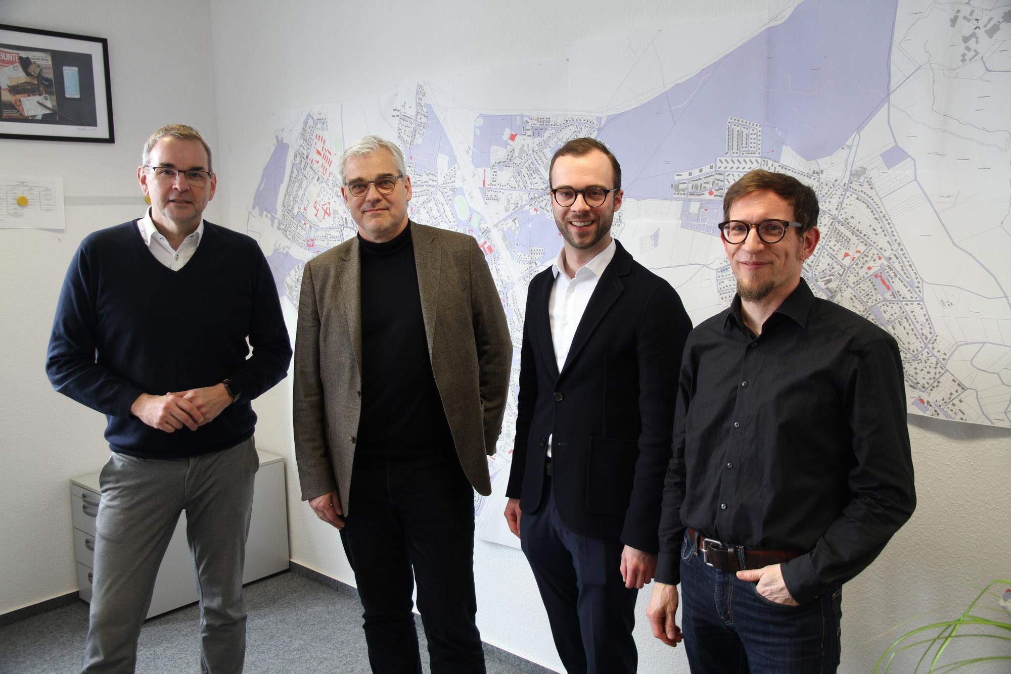 Vier Männer stehen vor einem Stadtplan