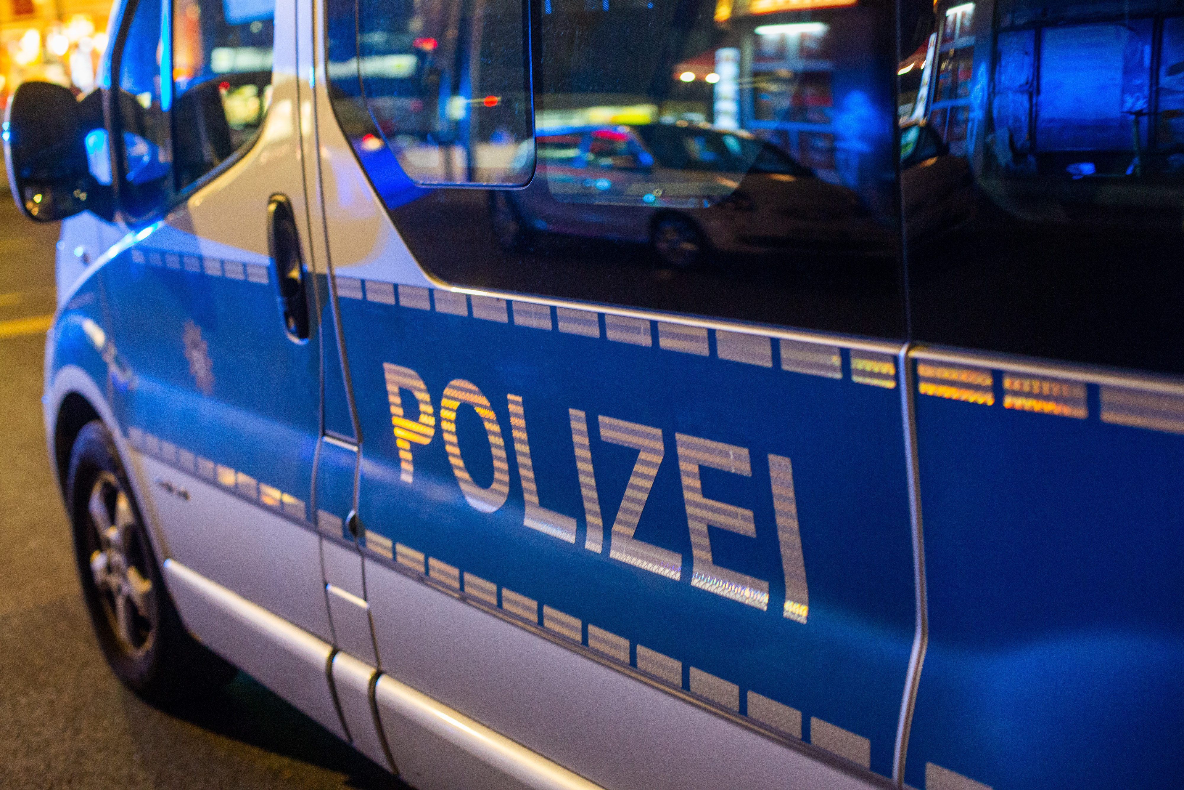 Ein Polizeifahrzeug steht bei einem Einsatz in der Nacht auf der Straße.