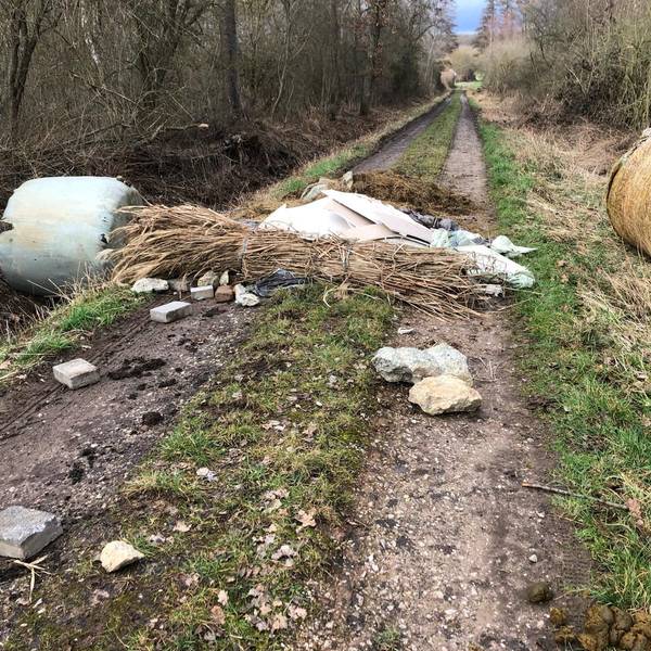 Auf einem Feldweg im Wäldchen des Kalkarer Moores liegt illegal entsorgter Müll.