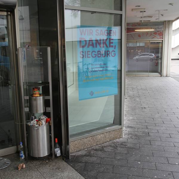 Ein überquellender Mülleimer neben dem Eingang eines geschlossenen Kaufhauses