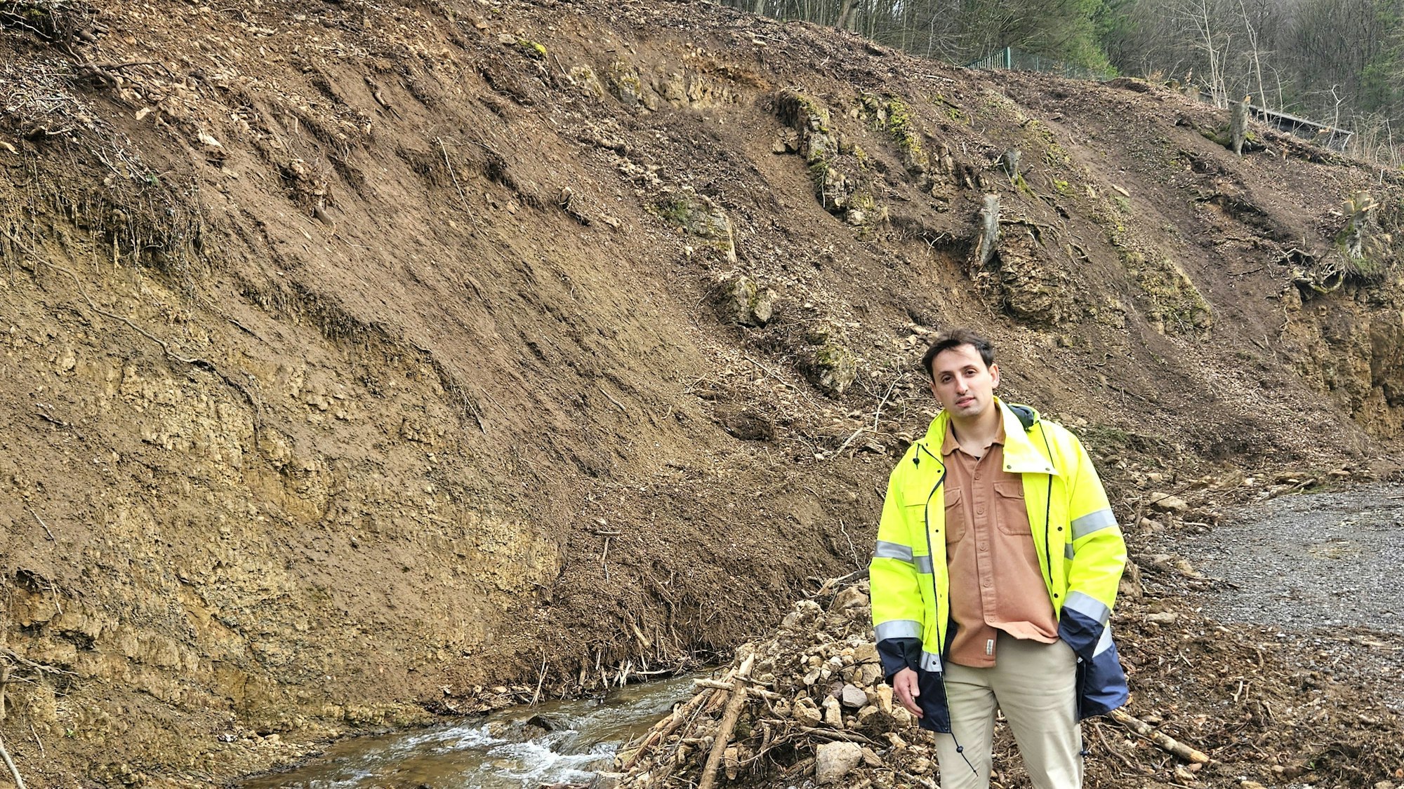 Eduard Zubiks steht am Gillesbach vor einem kahlen Hang.