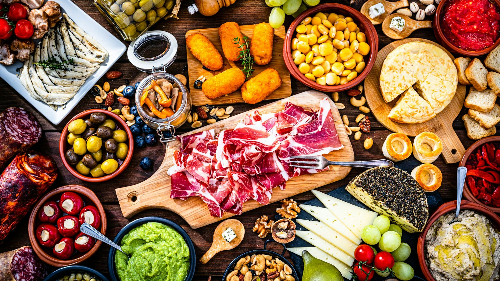 Viele kleine Schalen mit vielen bunten Köstlichkeiten auf einem Tisch.