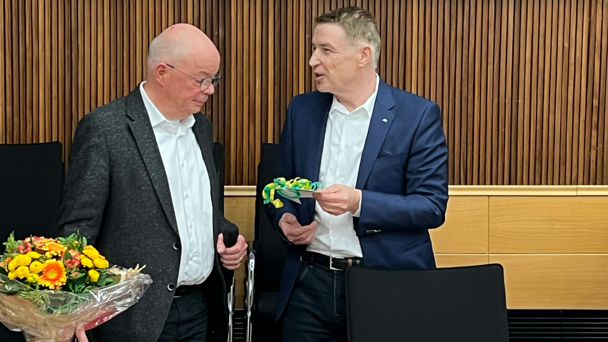 Kreisdirektor Dr. Erik Werdel (r.) überreicht im Kreis-Sozialausschuss den langjährigen Chef des Jobcenters, Michael Schulte, ein Geschenk.