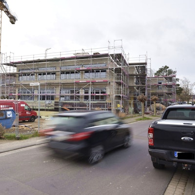 Ein Auto fährt an dem eingerüsteten Bau am Zülpicher Schulcampus vorbei.