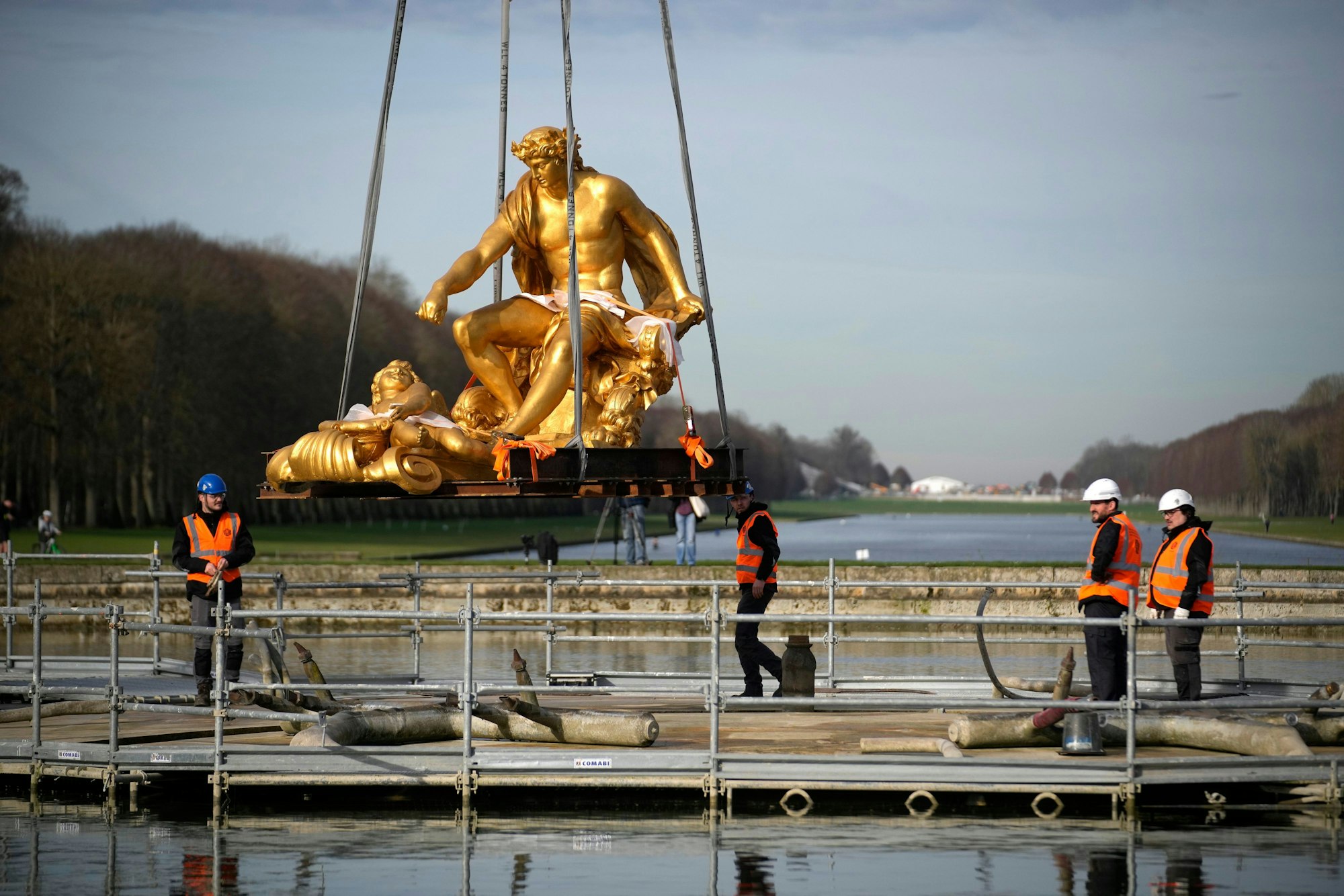 Versailles: Arbeiter setzen die Skulptur ‚Apollon sur son char‘ (Apollo auf seinem Wagen) ab, um sie nach ihrer Restaurierung in den Gärten des Schlosses von Versailles außerhalb von Paris wieder im Apollo-Brunnen aufzustellen. Das Schloss von Versailles stellt den Apollo-Wagen, ein Meisterwerk aus dem 17. Jahrhundert, nach einer umfassenden Restaurierung im Vorfeld der Olympischen Spiele in Paris wieder auf, bei denen die Anlage Schauplatz für Pferdesport sein wird.