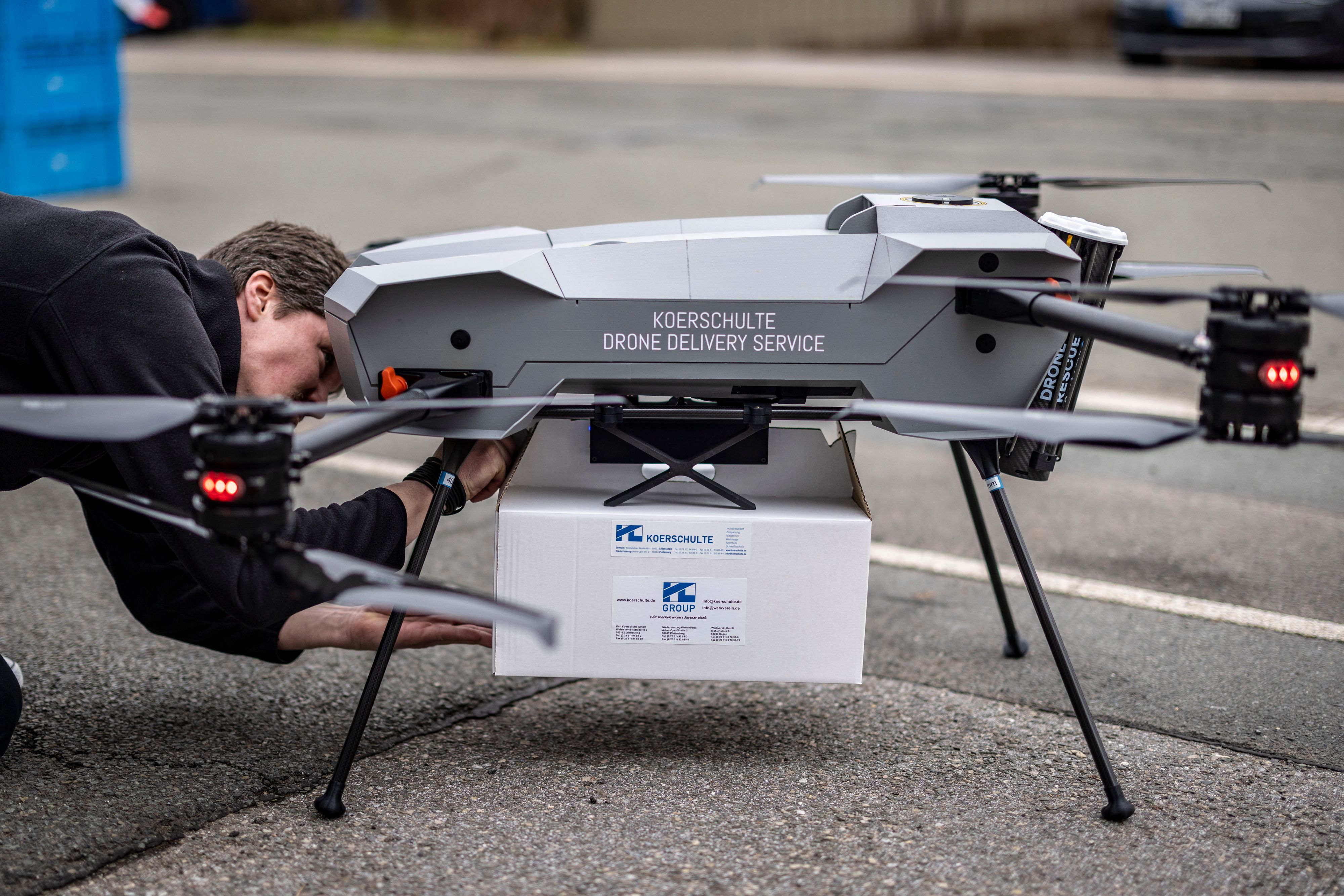 Ein Techniker befestigt das zu liefernde Paket an einer Drohne vom Hersteller Third Element Aviation aus Bielefeld.