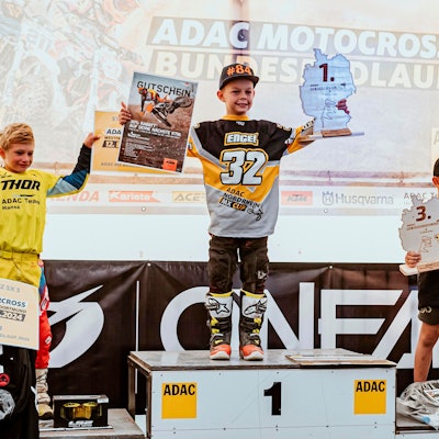 John Engel aus Kuchenheim hält in der einen Hand einen Gutschein, in der anderen den Pokal in Form der Umrisse Deutschlands, darauf steht die Platzierung 1.