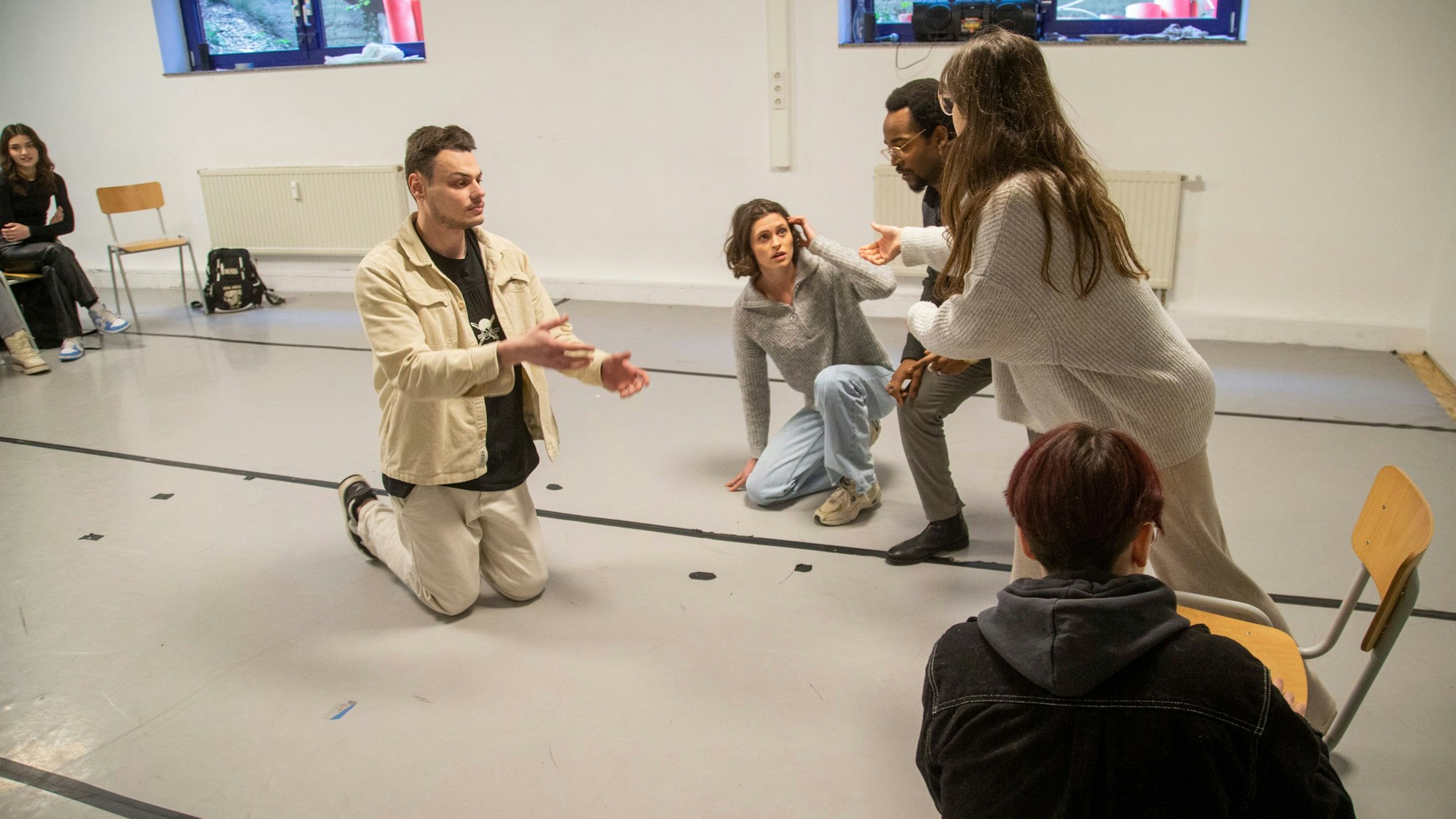 Junge Männer und Frauen machen große Gesten.