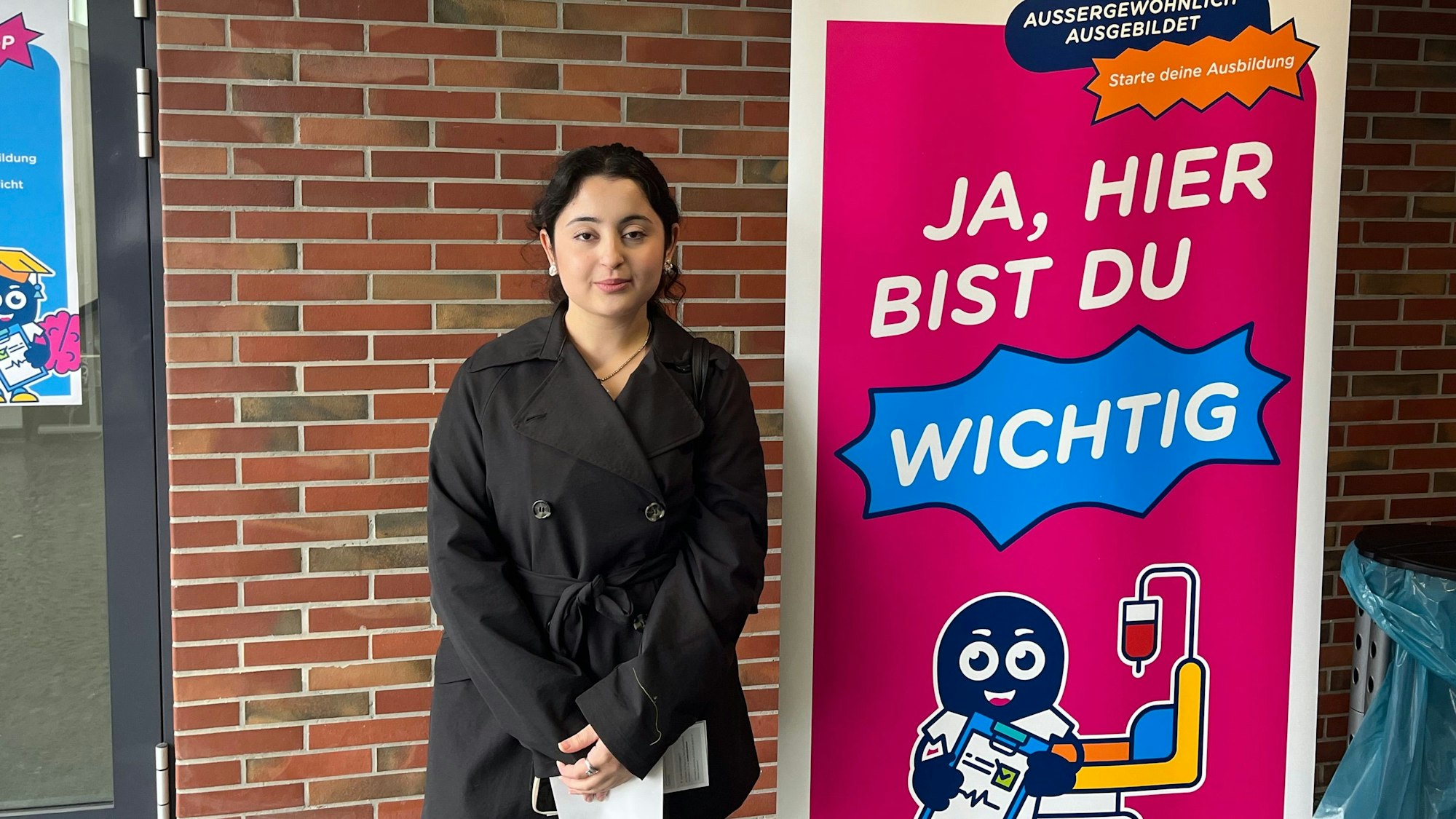Eine Frau steht neben einem Plakat mit der Aufschrift: Ja, hier bist du wichtig.