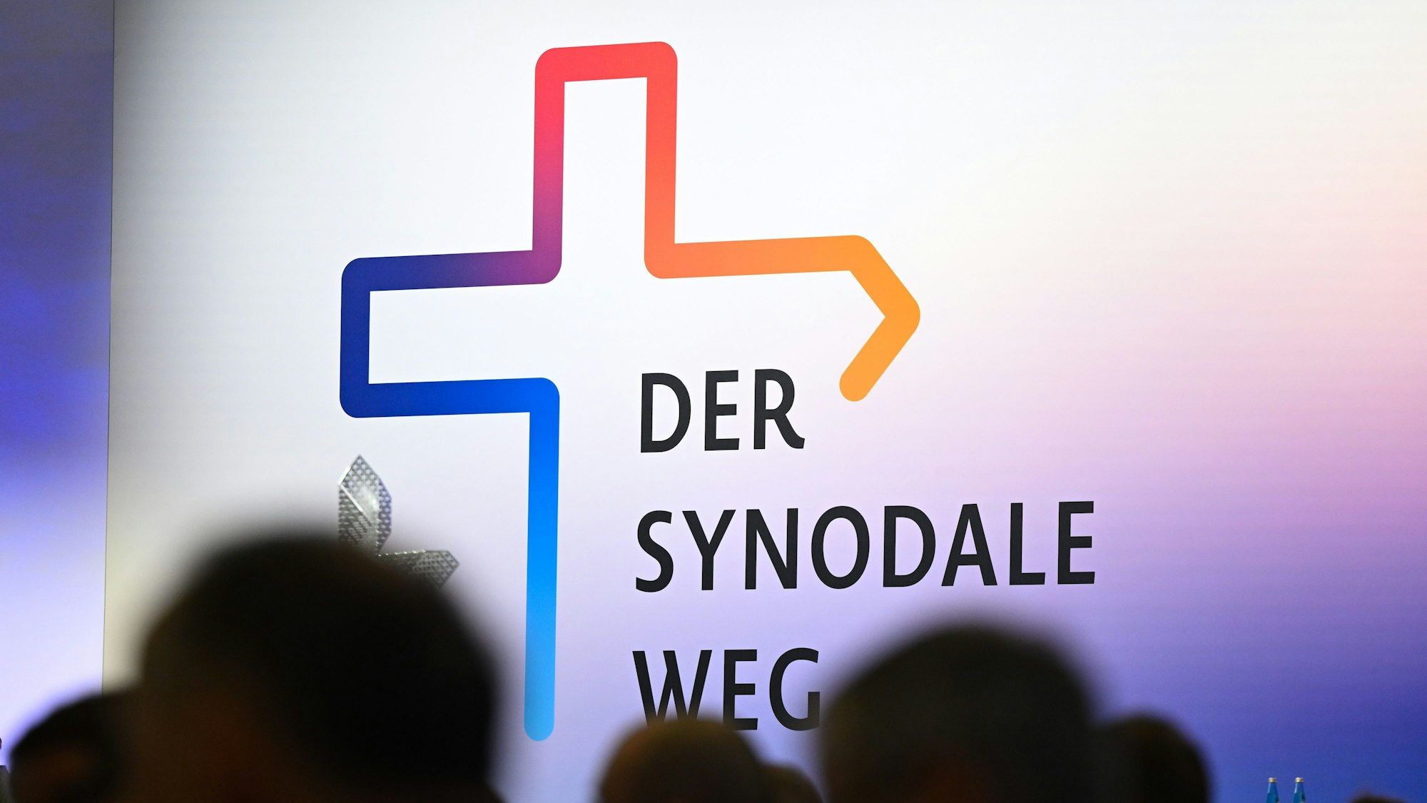eilnehmer der Synodalversammlung sitzen vor dem Schriftzug „Der Synodale Weg“.