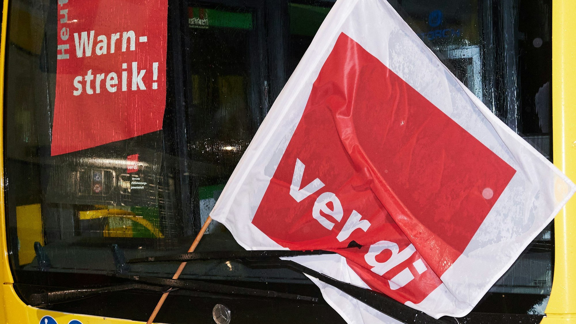 Eine Verdi-Fahne an einem Bus. Die Gewerkschaft ruft zu neuen Streiks auf. (Symbolbild)