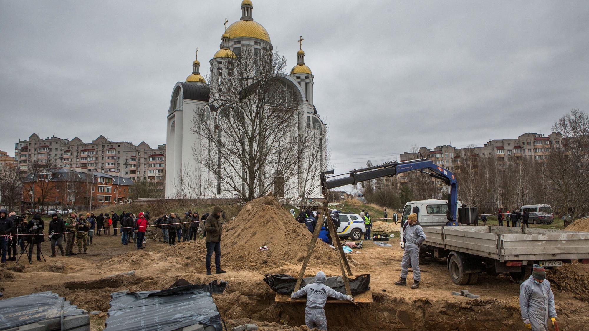 Forensic technicians exhume the bodies of civilians who Ukrainian officials say were killed during Russia’s invasion and then buried in a mass grave in the town of Bucha, outside Kyiv, Ukraine April 13, 2022. REUTERS/Volodymyr Petrov