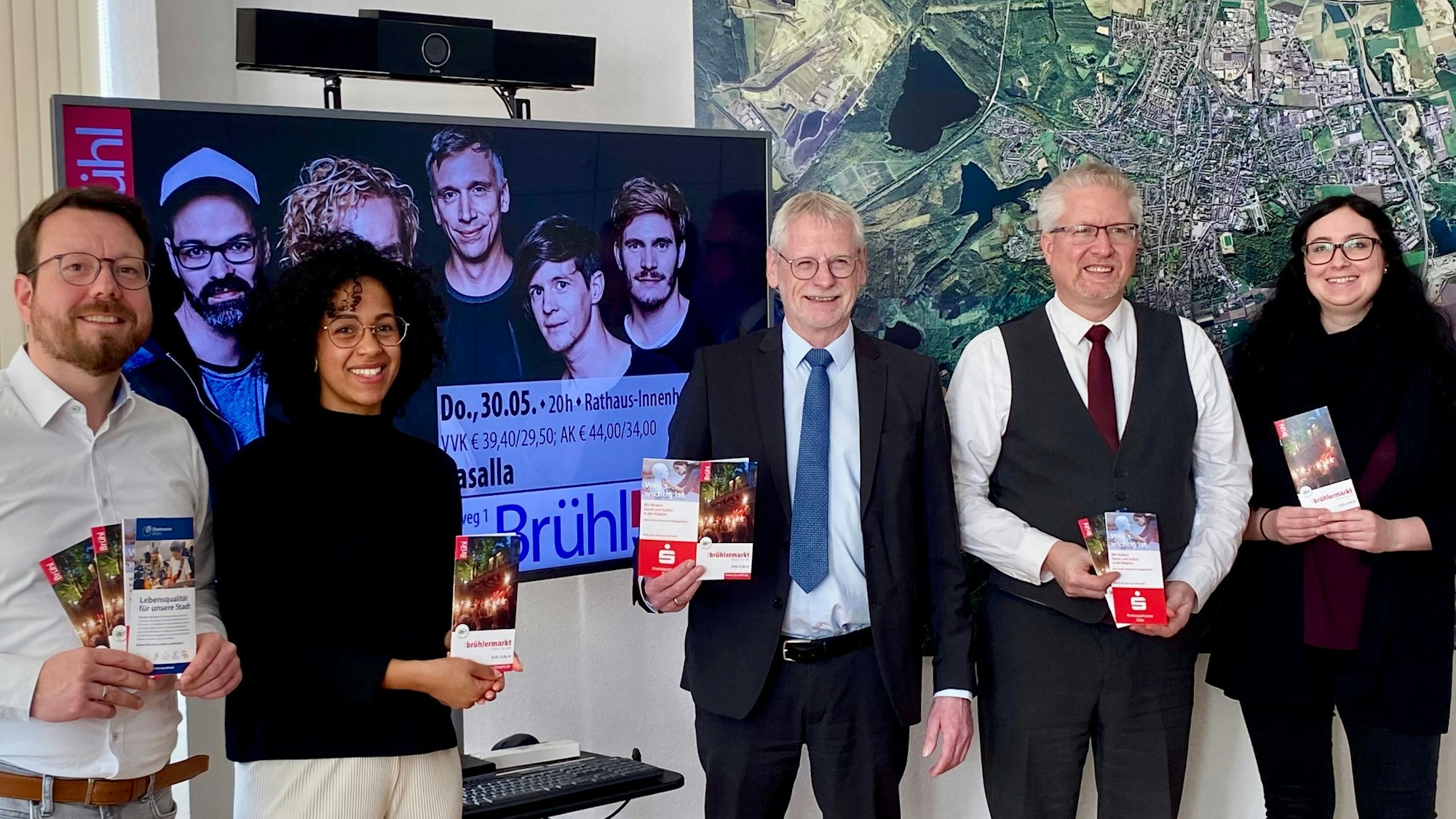 Zu sehen sind Organisatoren und Sponsoren des Festivals, sie halten Programmhefte in der Hand.