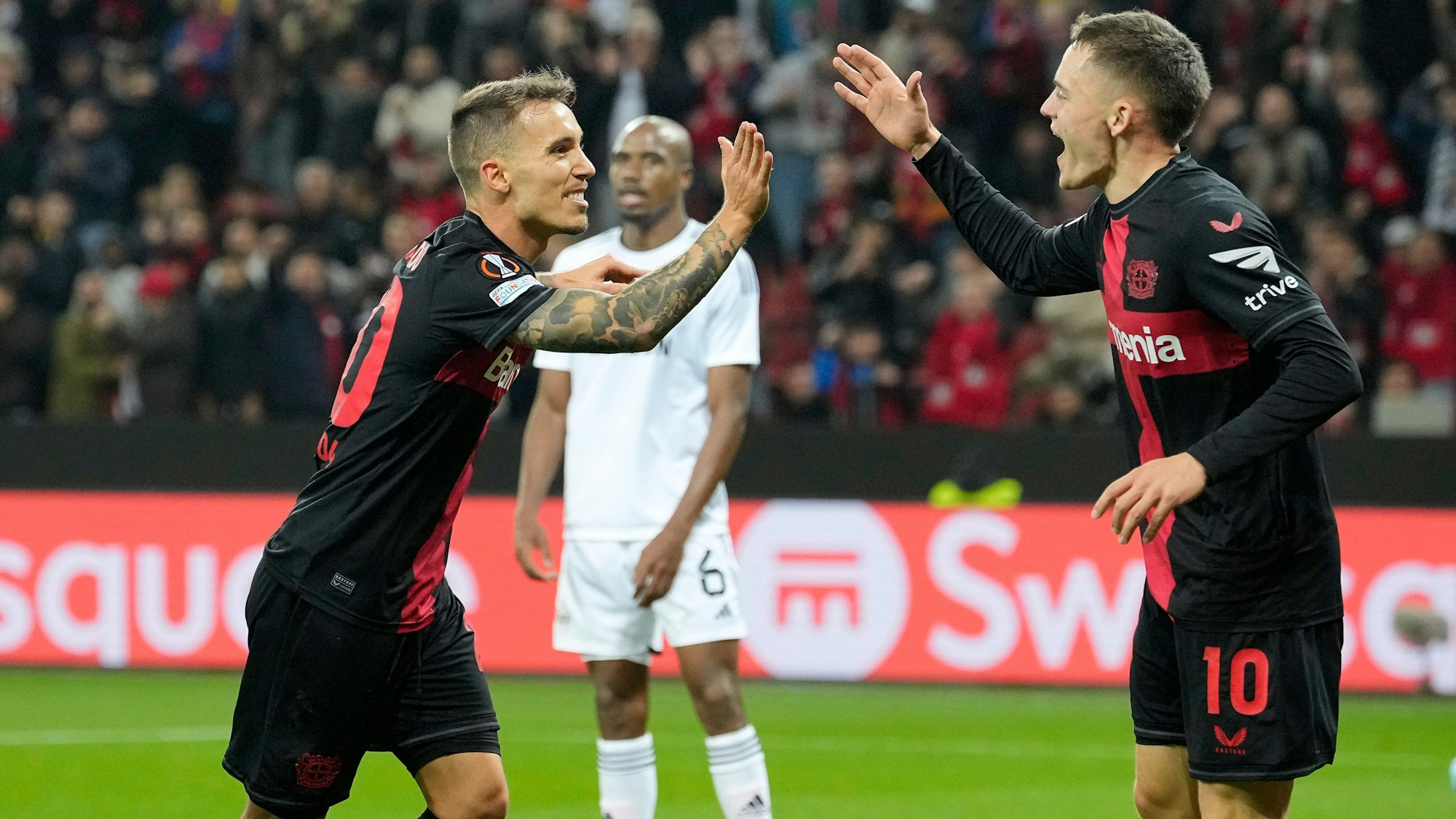Leverkusens Alex Grimaldo, links, jubelt neben Leverkusens Florian Wirtz, rechts, nach seinem zweiten Treffer während des Fußballspiels der UEFA Europa League Gruppe H zwischen Bayer Leverkusen und Qarabag in der BayArena.