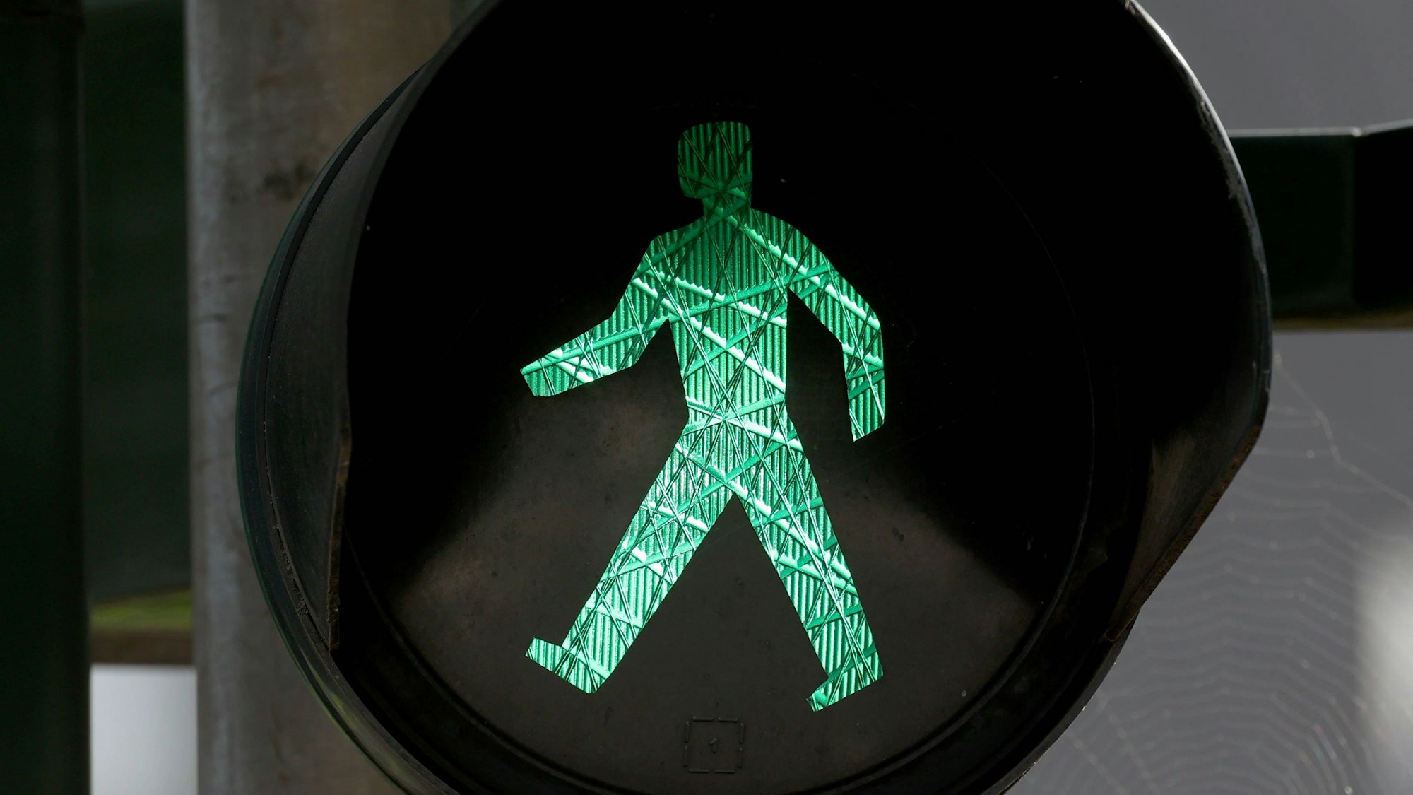 Grünes Ampelmännchen auf einer Verkehrsampel.
