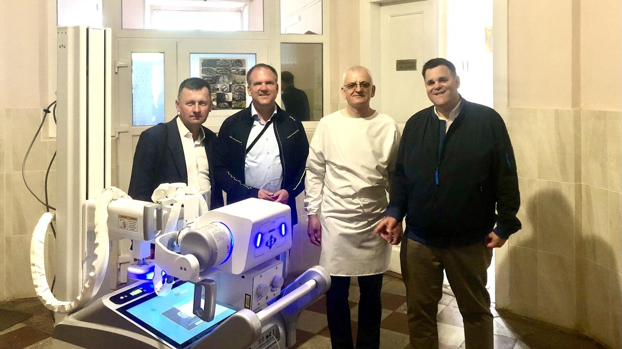 Vier Männer in einem ukrainischen Krankenhaus hinter einem Röntgengerät.
