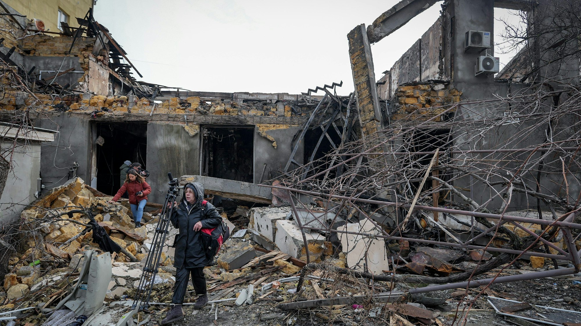 23.02.2024, Ukraine, Odessa: Journalisten filmen nach einem nächtlichen Drohnenangriff die zerstörte Näherei in der Hafenstadt Odessa.