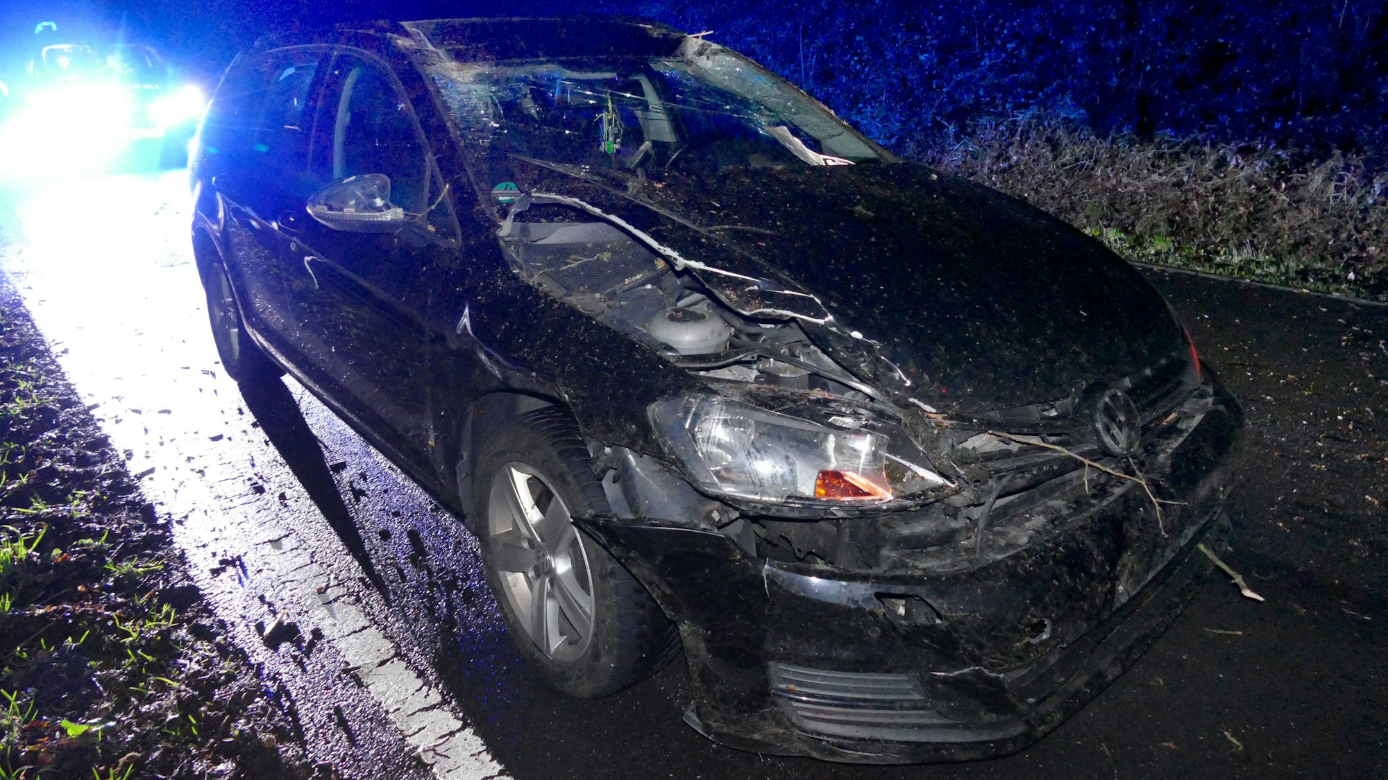 Ein zerstörtes Auto steht auf einer Straße.