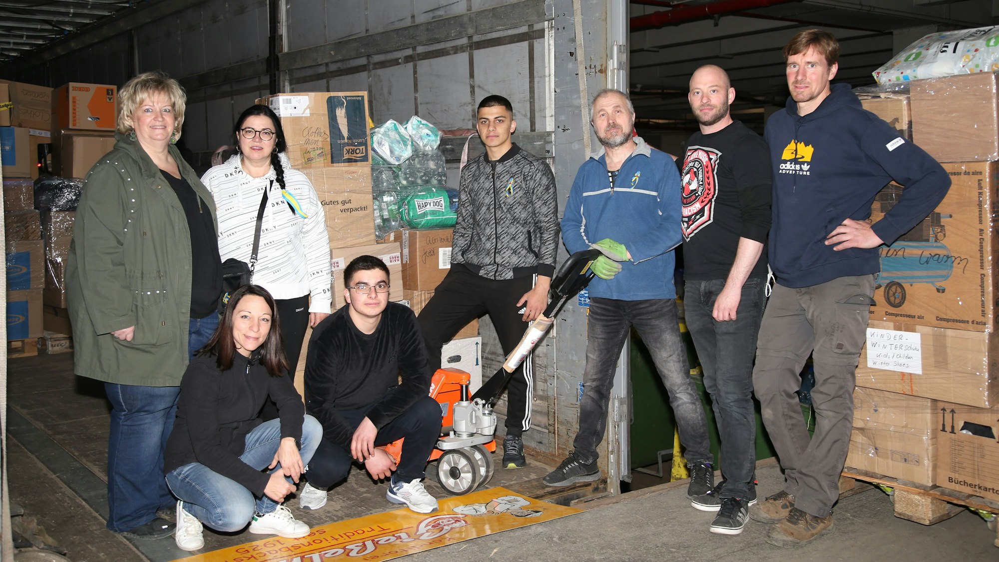 Mehrere Männer und Frauen beladen einen Lkw mit Hilfsgütern für die Ukraine.