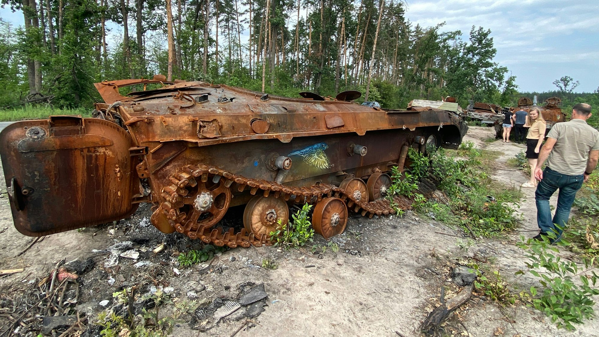 Bergisch Gladbachs Feuerwehrchef Jörg Köhler geht an einem ausgebrannten Panzerwrack bei Butscha vorbei.