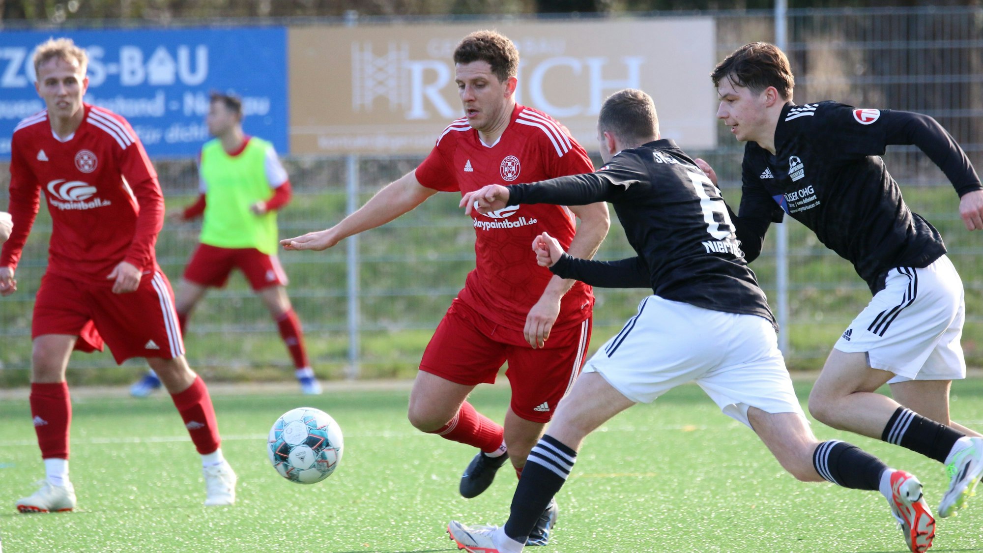 Der Zülpicher Spieler Fabian Bentata führt den Ball, zwei Nierfelder bedrängen ihn.
